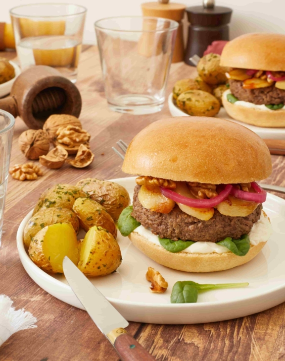 Burger aux pickles d’oignon rouge, poires confites, noix et sauce au chèvre